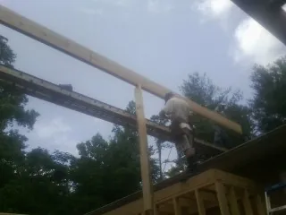 Carpenter setting a ridge beam over a new addition frame — Ice Dam Removal by Roofing Brothers in Chaplin