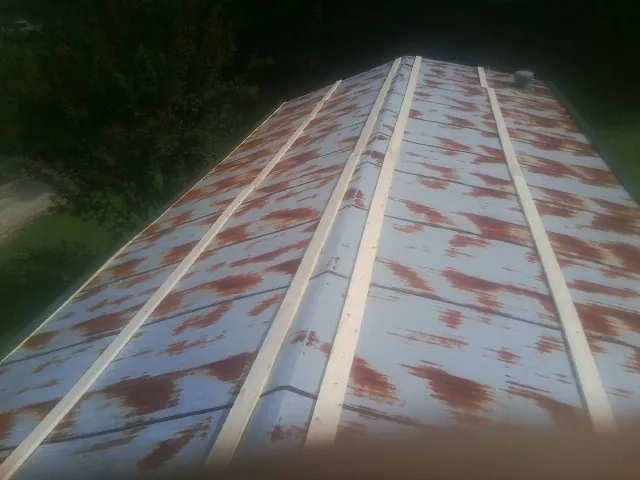 Rusted metal roof panels with new wood purlins before replacement — Storm Damage Roof Repair in Chaplin by Roofing Brothers